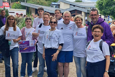 Bild zeigt Seniorenmoderatorin Dunja Kolaric-Wilhelm, Wirtschaftsförderer Manuel Buchheit, Landrat Patrik Lauer, Innenminister Reinhold Jost und Vertreter von Vereinen und Schulen der Gemeinde Schmelz beim Fackeltag des Landkreises Saarlouis für die Special Olympics Nationalen Spiele